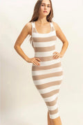 A woman modeling a fitted ribbed knit midi dress with horizontal beige and white stripes against a plain light background.