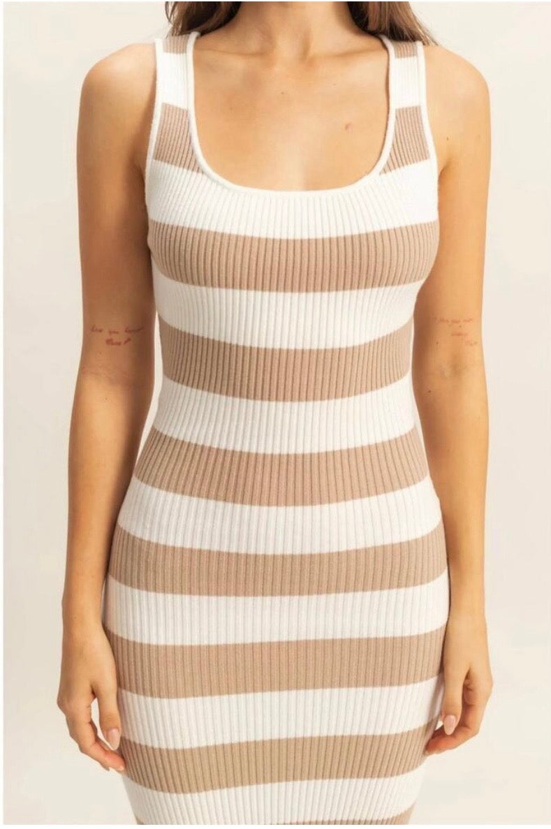 A woman wearing a sleeveless ribbed knit bodycon dress with horizontal beige and white stripes, shown from the shoulders to the hips against a plain light background.