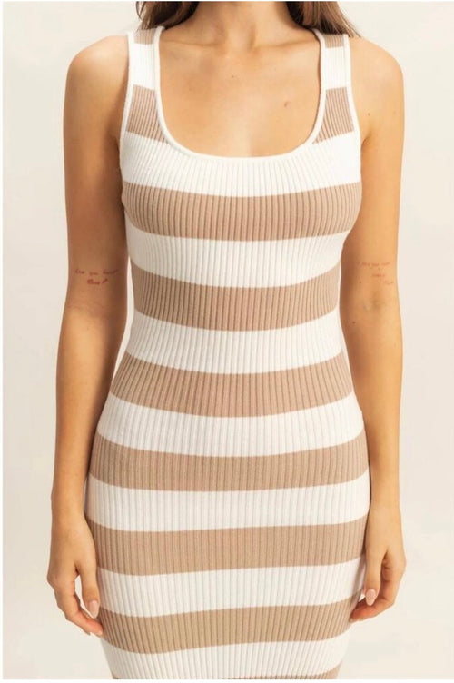 A woman wearing a sleeveless ribbed knit bodycon dress with horizontal beige and white stripes, shown from the shoulders to the hips against a plain light background.
